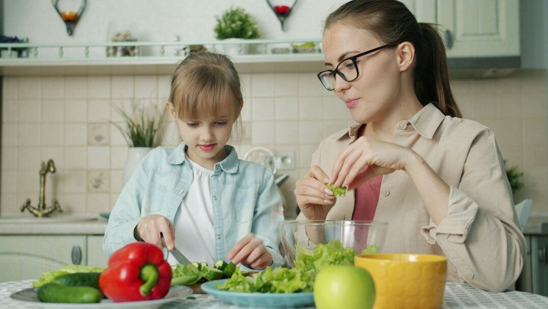 Nutritionist arranging fresh vegetables and a meal plan on a kitchen counter