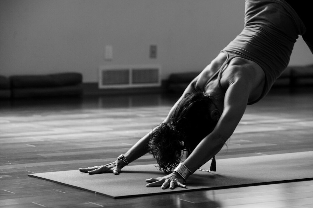 Instructor guiding a small group through a yoga pose in a sunlit studio