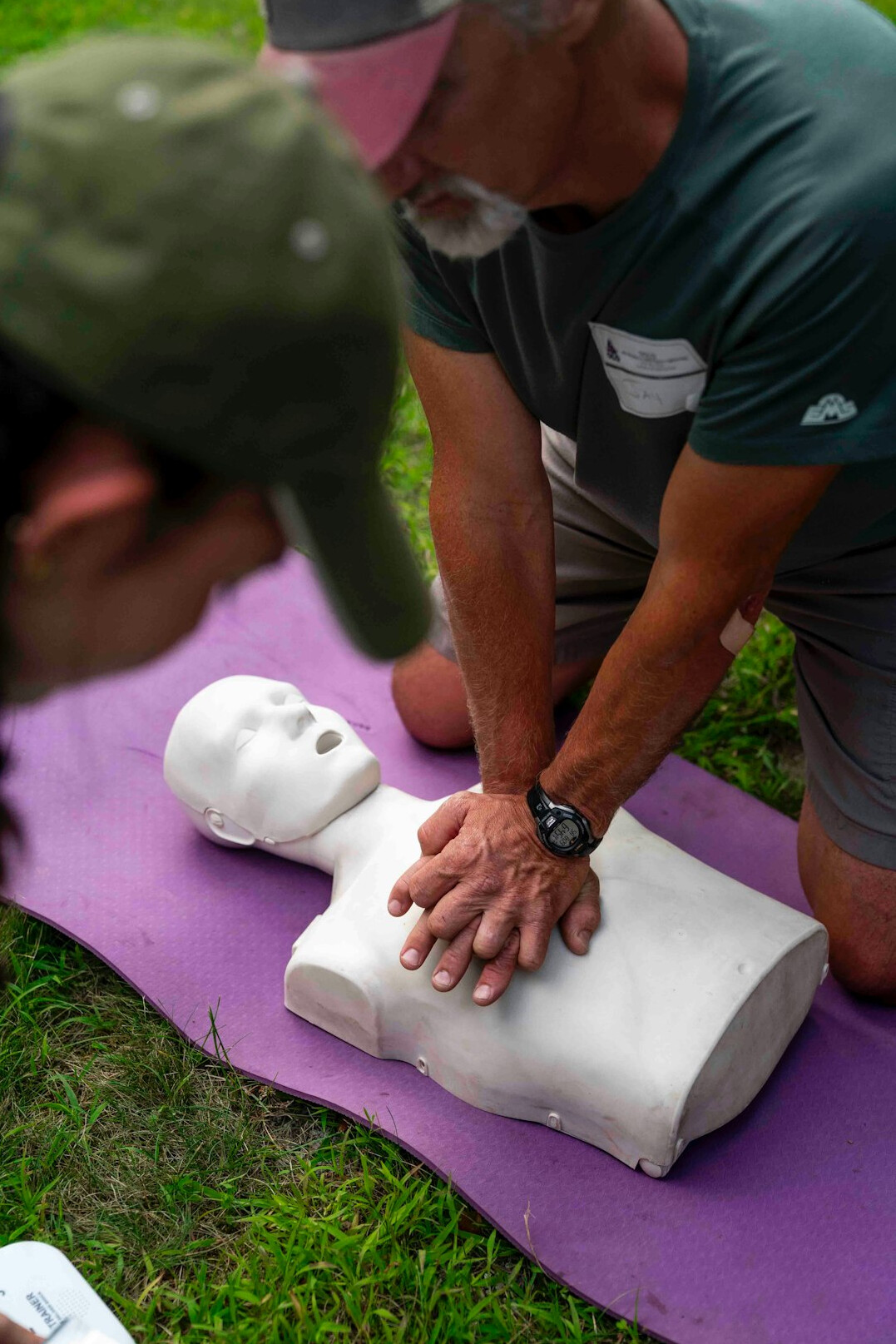 Instructor demonstrating CPR technique on a training mannequin
